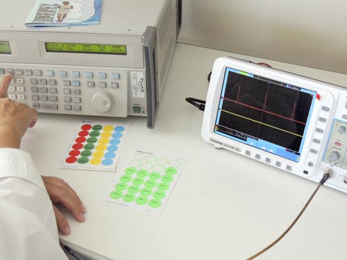 Laboratory technician works with Fluke 5522A Calibrator. Pass/ Fail stickers to mark the tested equipment. Laboratory technician works with Fluke 5522A Calibrator. Pass/ Fail stickers to mark the tested equipment.